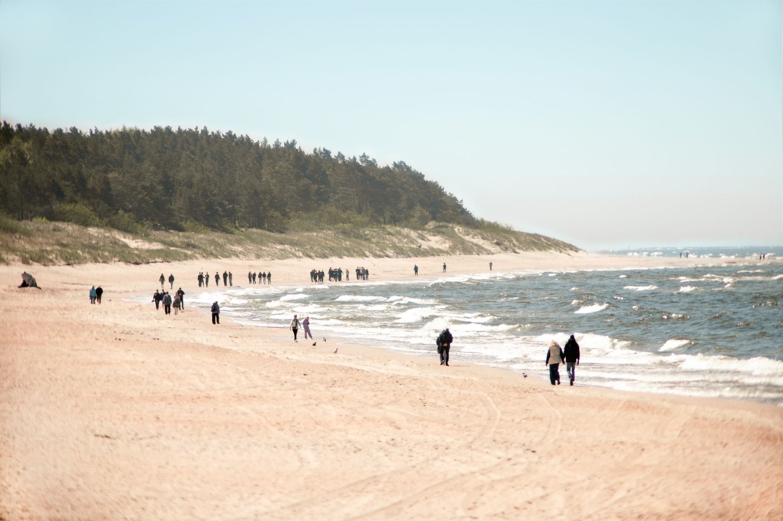 People walking along the calm Palanga beach in Lithuania