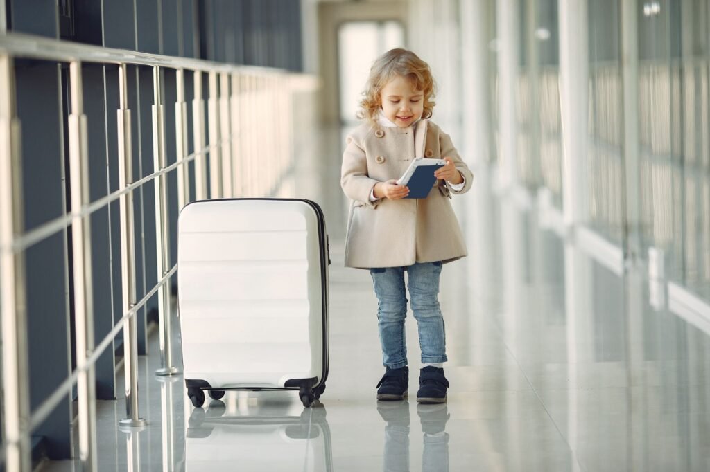 Little girl with suitcase and passport – Lithuanian passport for a child