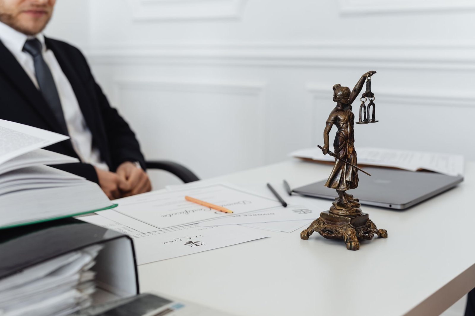 A legal professional's workspace with Lady Justice statue and documents