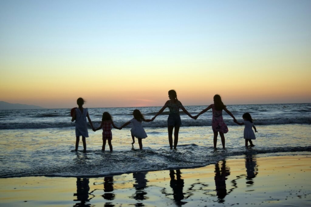 A family holding hands on a beach at sunset