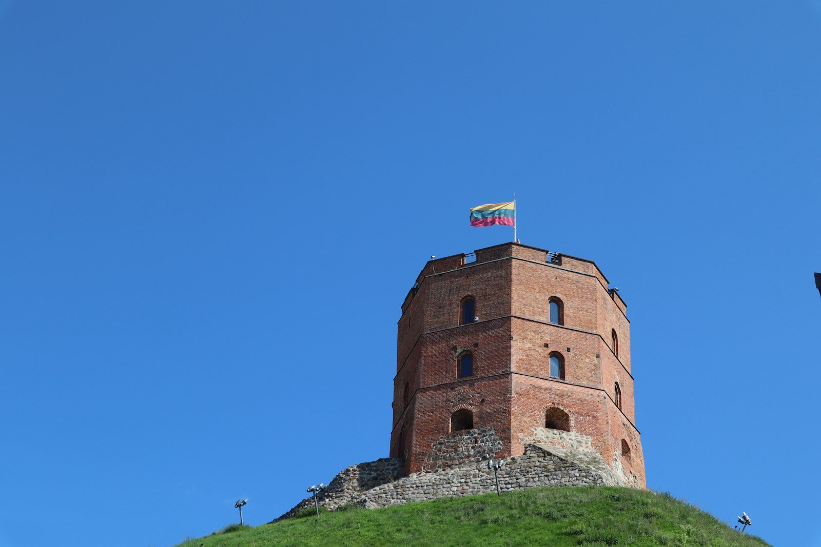 The Lithuanian flag flying on a historic tower